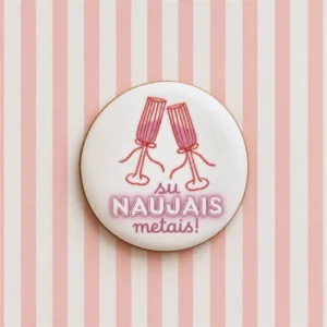 Supakuotas apvalus meduolis su šampano taurėmis ir užrašu „Su Naujais metais“